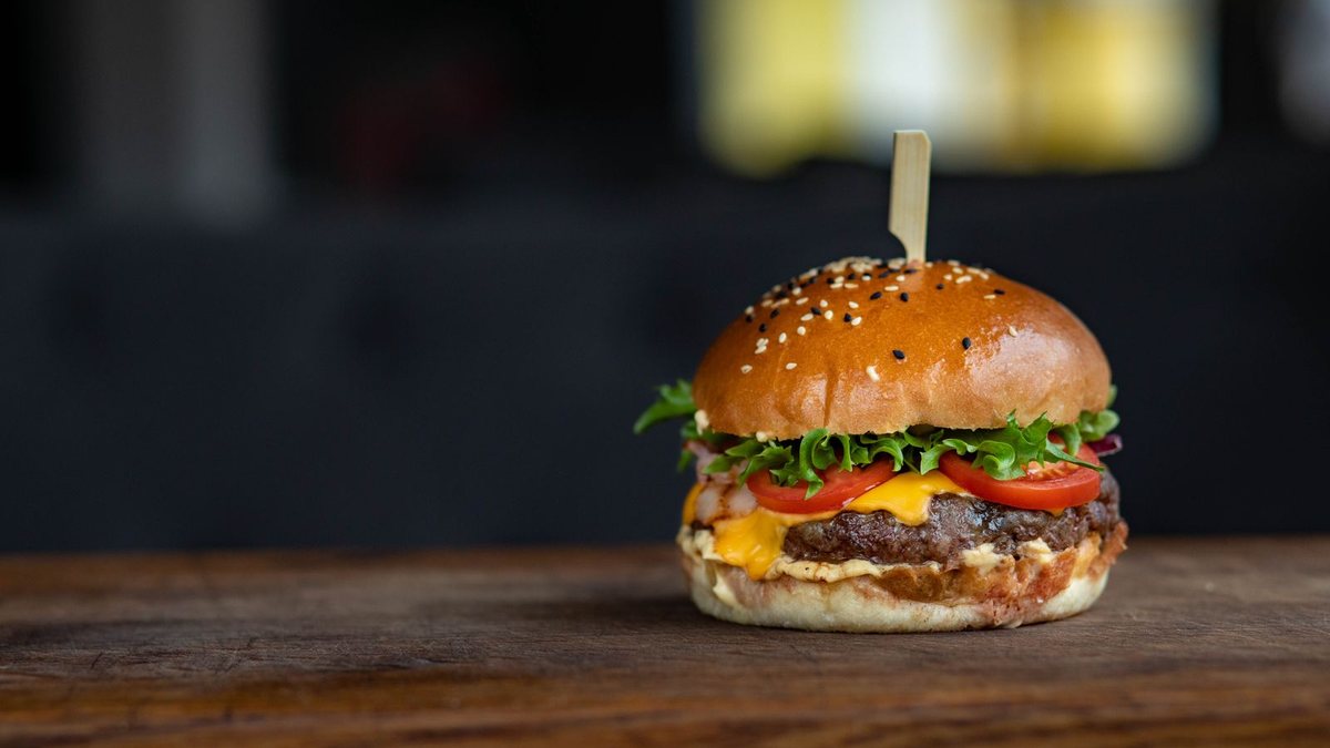Burger maison au pain brioché sur une planche en bois