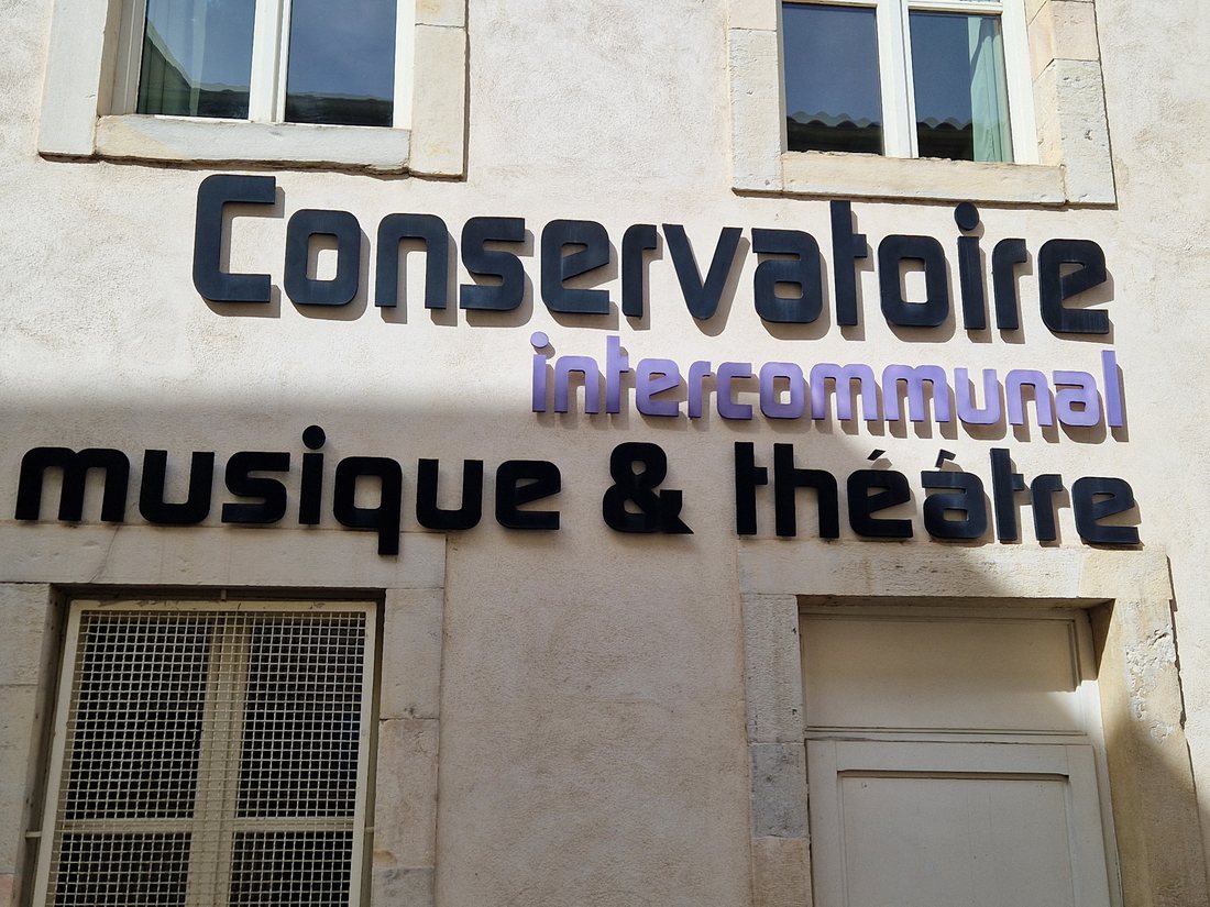 La façade en pierre du conservatoire intercommunal de Montélimar, rue Bouverie, avec les lettres découpées Conservatoire intercommunal musique et théâtre