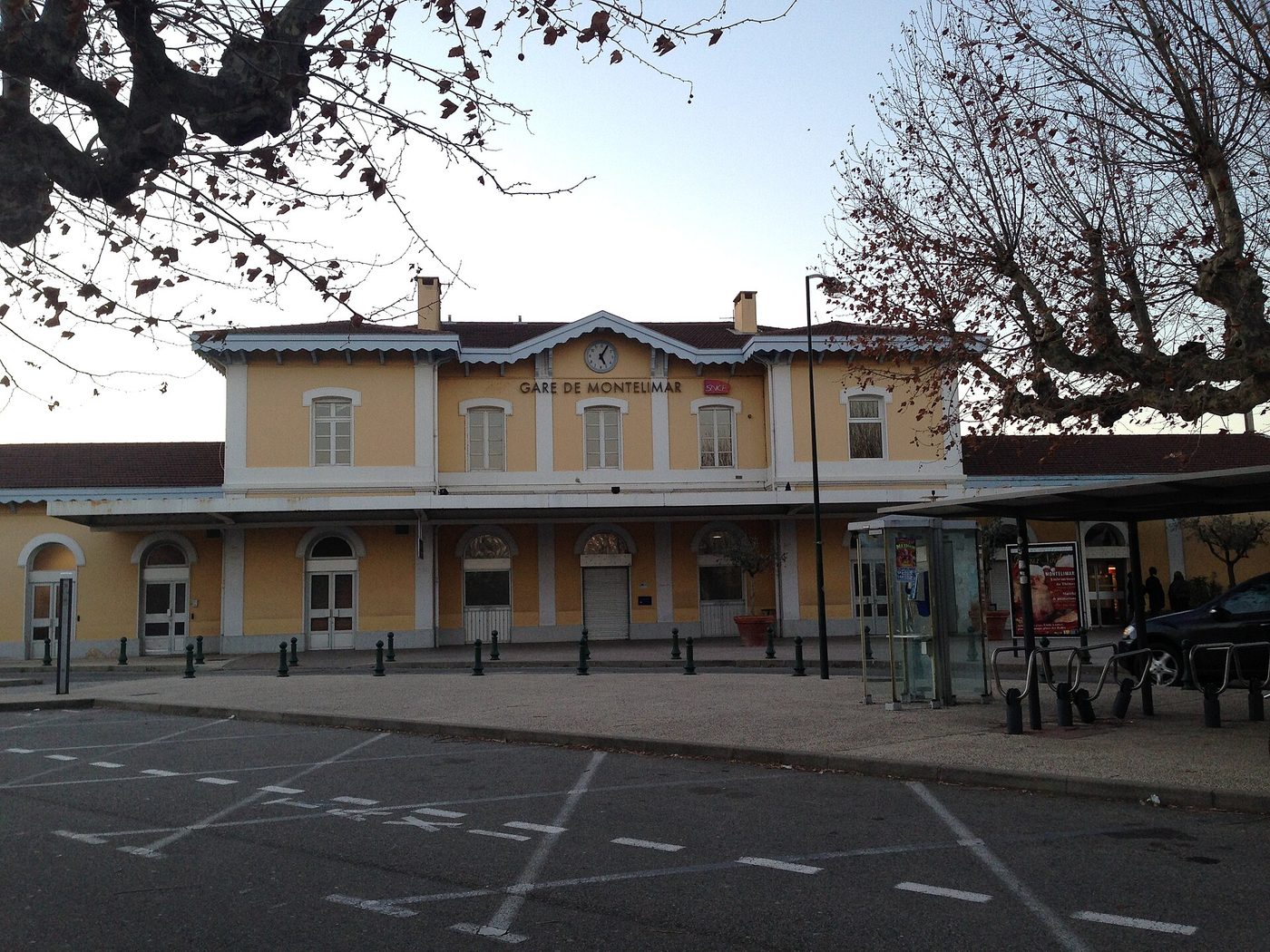 La façade de la gare de Montélimar et son parvis, avec l'horloge et l'enseigne SNCF