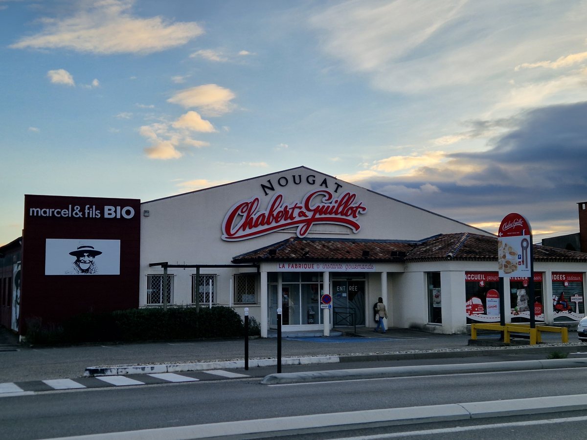 La boutique Chabert et Guillot de l'avenue de Gournier au soleil couchant, avec son enseigne rouge