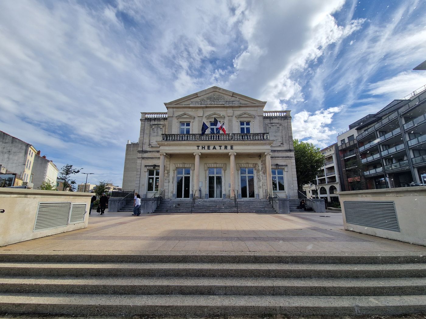 La façade néoclassique du théâtre de Montélimar, son fronton sculpté et le large escalier qui monte au parvis