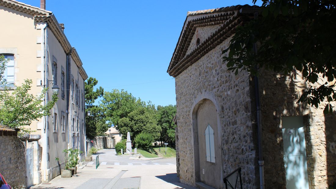 Rue de Cliousclat bordée de maisons de pierre et de crépis clairs